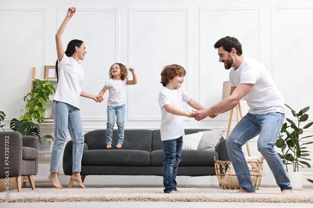 Fototapeta premium Happy family dancing and having fun in living room