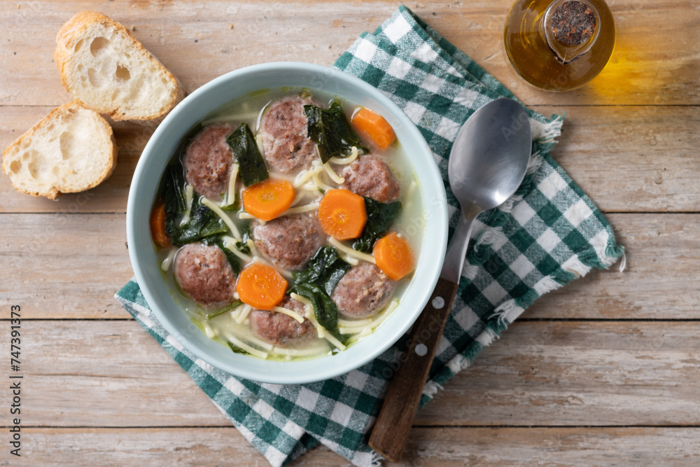 Italian Wedding Soup with meatballs and spinach on wooden table. Top view Italian Wedding Soup with meatballs and spinach on wooden table. Top view