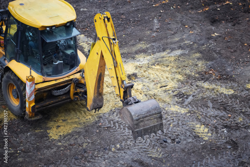 the excavator bucket begins work, yellow excavator on a land construction site