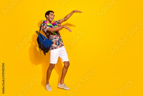Full length body photo of boogie woogie dancing guy in shorts t shirt and hawaii style necklace isolated on yellow color background