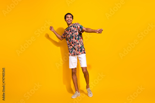 Full body length size photo of funky young man in t shirt with white shorts discotheque summertime isolated on yellow color background