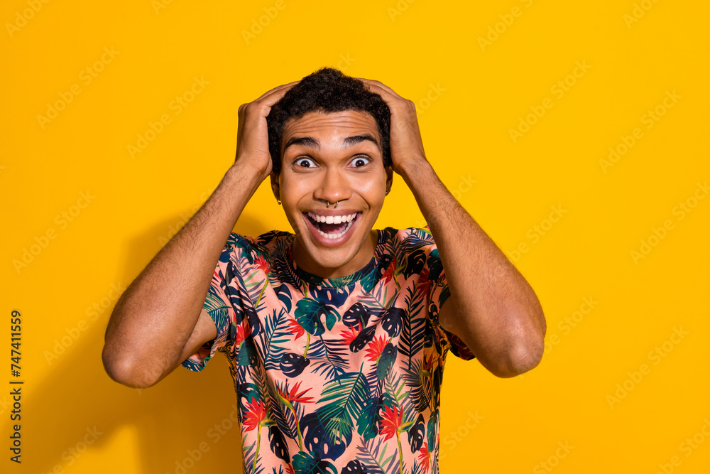 Photo of excited shocked guy dressed print t-shirt arms head empty space isolated yellow color background Photo of excited shocked guy dressed print t-shirt arms head empty space isolated yellow color background