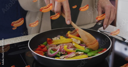 Image of hot dogs icons with senior caucasian couple cooking