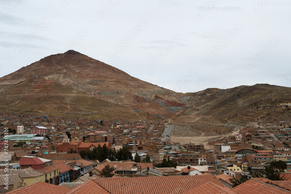 Cerro Rico Mountain on the left with houses that extend to the foot of the hill and road in the distance that leads to the mountain