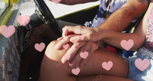 Image of hearts over caucasian couple in car