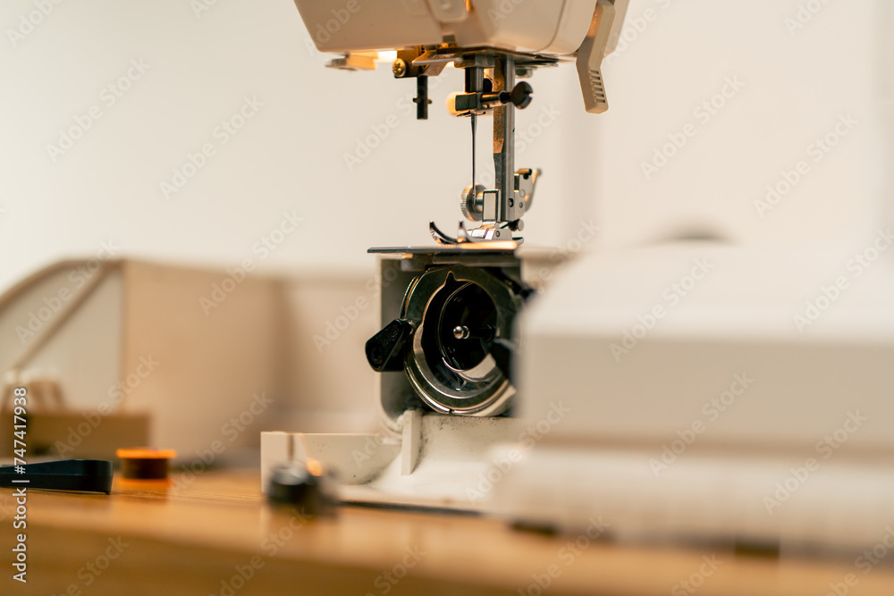 Fototapeta premium close-up in a sewing workshop a half-assembled sewing machine tongs and threads