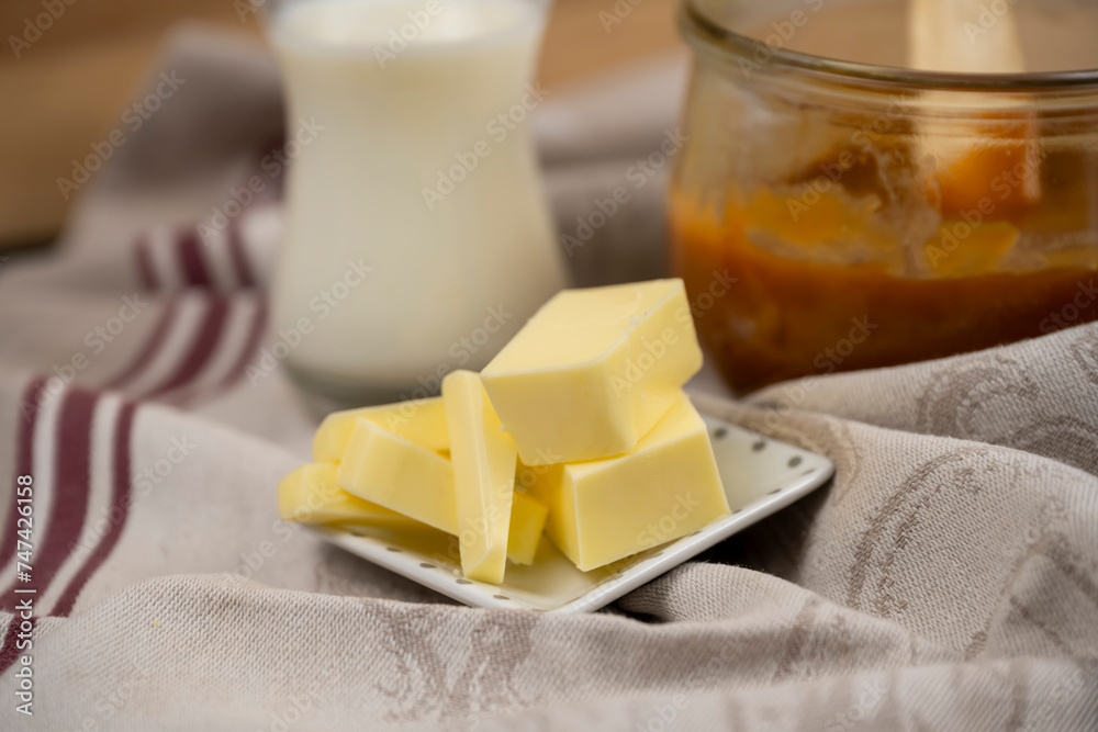 beurre salé en morceaux dans une petite coupelle, ingrédient pour une recette de caramel au beurre salé maison