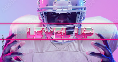Картината върху платно Image of level up text over american football player and neon lines