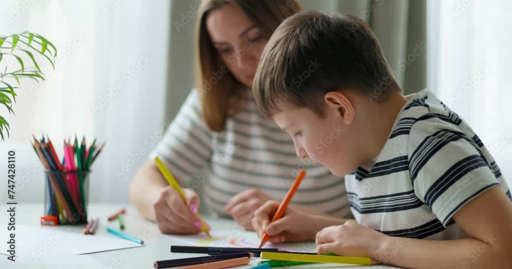 Mother and child engaged in drawing together at home Mother and child engaged in drawing together at home