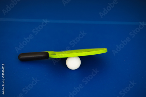 Blue ping pong table. Green Ping pong racket and ball. The concept of sport and healthy lifestyle. Table tennis