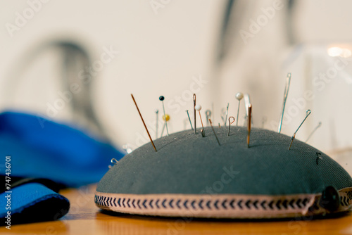 close-up in a sewing workshop pin cushion is completely stuffed with needles and pins