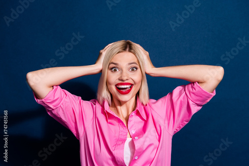 Portrait of overjoyed positive woman wear stylish shirt keep hands on head staring open mouth isolated on dark blue color background
