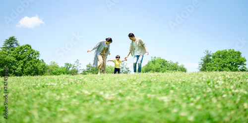 緑の丘で遊びまわる家族 photo