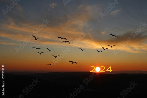Transition from 2023 to new year 2024 concept with text on sun rising sky. Life is short birds are flying. © Abdulkadir