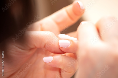 Woman removing nail varnish with acetone photo
