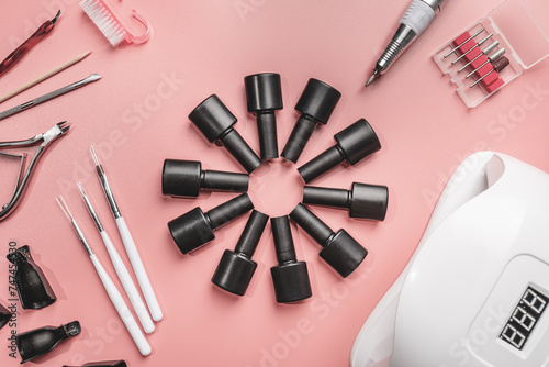manicure and pedicure tools and other nail essentials on pink background top view. nail work flat lay concept