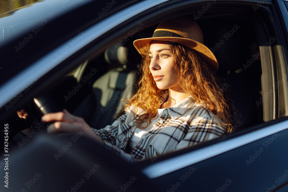 Beautiful young woman driving her car. Woman traveler. Summer vacation and adventure.