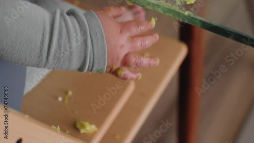 Baby boy's hand covered in avocado