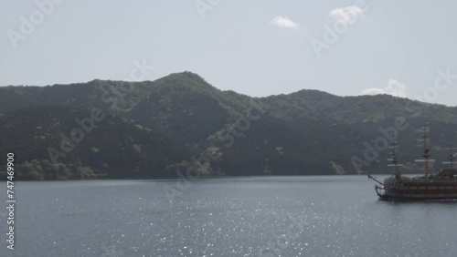 The sailboat glides on the lake's surface on a beautiful sunny day.