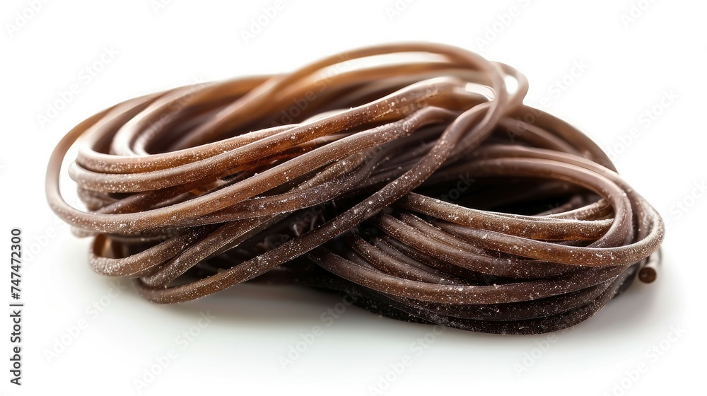 Coiled brown licorice candy strands on a white background.