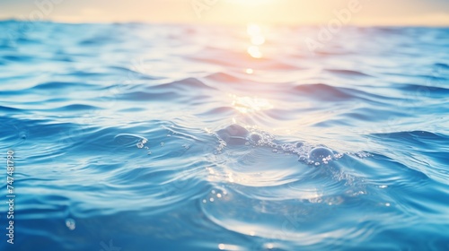 Abstract nature summer or spring ocean sea background. Small waves on water surface in motion blur with bokeh lights from sunrise