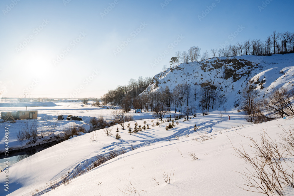 Beautiful mountain landscape, hilly area covered with snow, large snowdrifts on the mountainside, sunny day, frost