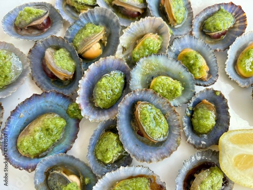 Canary Islands limpets with typical green “mojo” dip isolated close-up, seafood photo