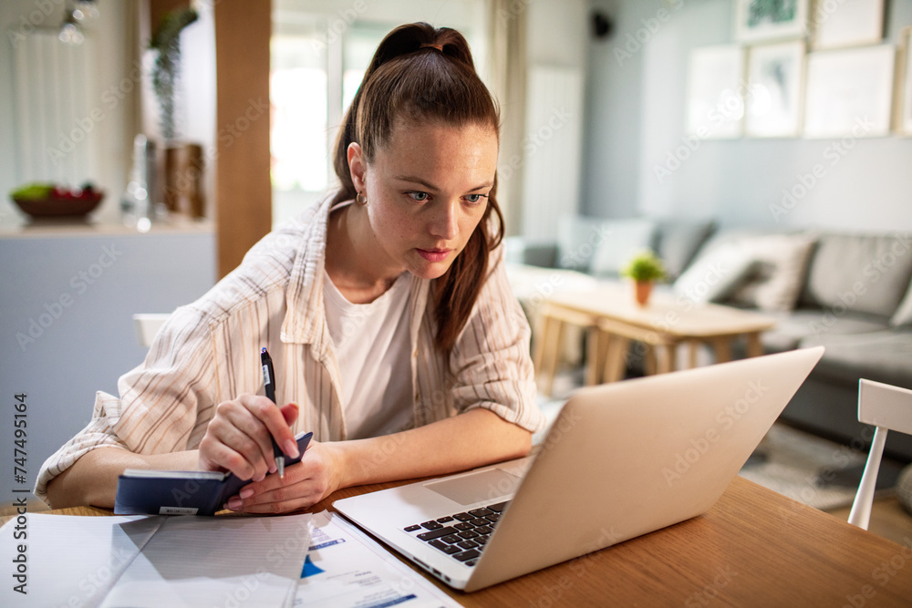 Stressed young woman working on laptop at home Stressed young woman working on laptop at home