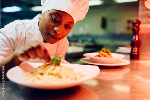 Foto African American female chef decorating food plate cooking in kitchen
