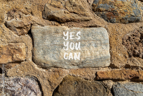 Motivational and Yes you can symbol. Concept words Yes you can on beautiful big grey stone. Beautiful stone wall background. Business motivational and Yes you can concept. Copy space.