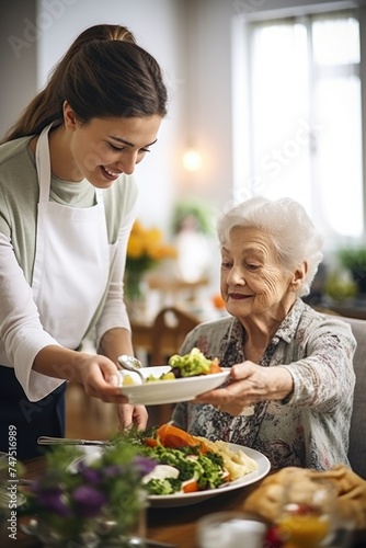 A woman serving a plate of food to an older woman. Useful for illustrating care and support for the elderly