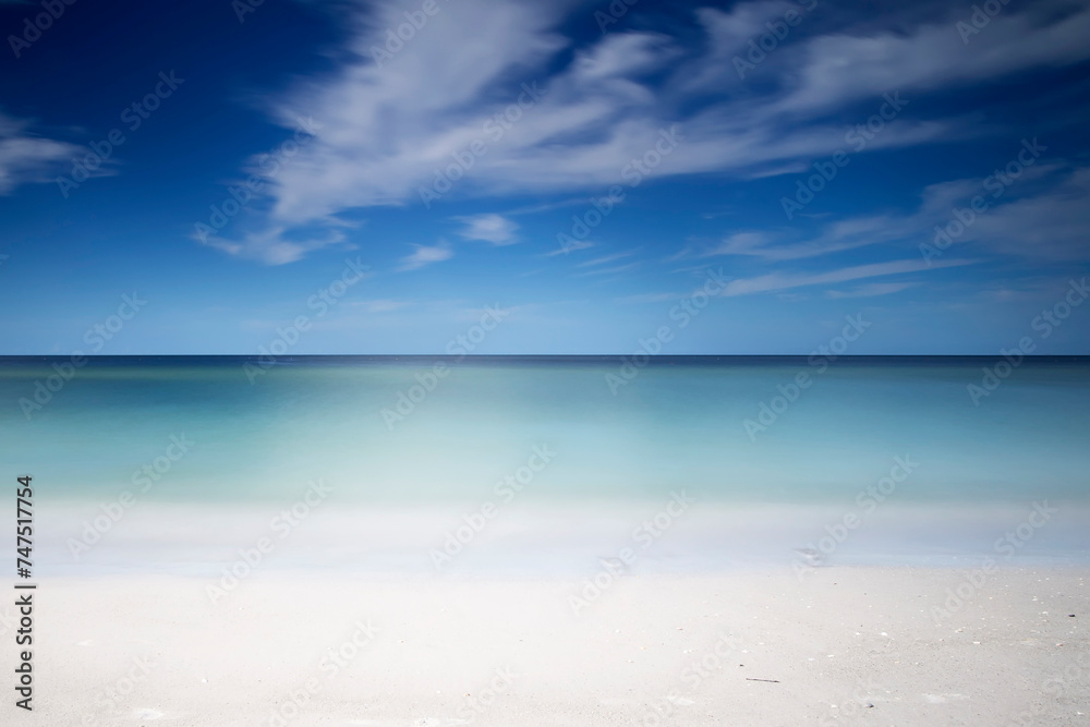 Symmetrical tropical white sand beach and calm sea background, calm
