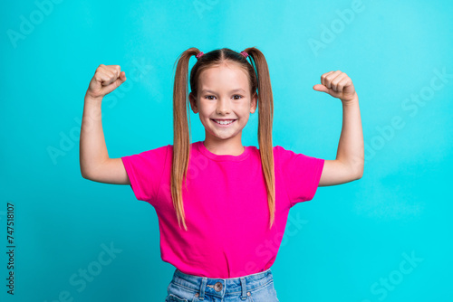 Photo of cute adorable active strong girl wear stylish clothes showing her power biceps triceps muscles isolated on cyan color background