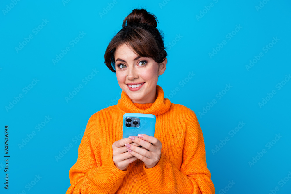 Photo of pretty good mood woman dressed orange sweater chatting instagram twitter telegram facebook isolated blue color background Photo of pretty good mood woman dressed orange sweater chatting instagram twitter telegram facebook isolated blue color background