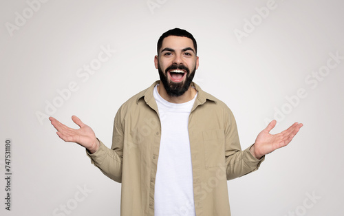 An exuberant man with a beard joyfully spreads his hands wide open