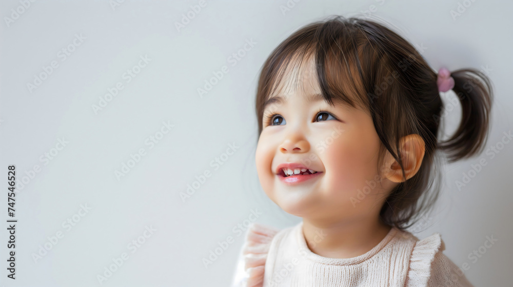 Closeup of a happy little Asian or Chinese toddler girl smiling, studio photography. Adorable female preschooler, innocent daughter looking at the camera, isolated on a white background Closeup of a happy little Asian or Chinese toddler girl smiling, studio photography. Adorable female preschooler, innocent daughter looking at the camera, isolated on a white background