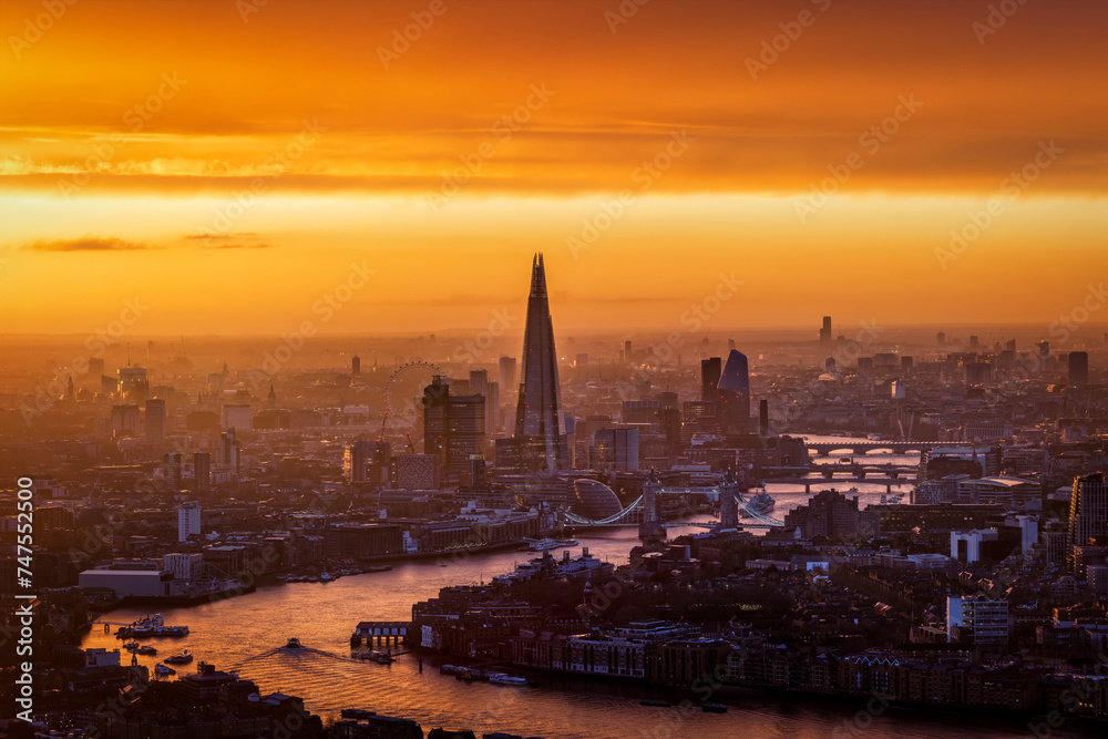 Golden sunset view of the urban skyline of London, England, with River Thames and office skyscrapers