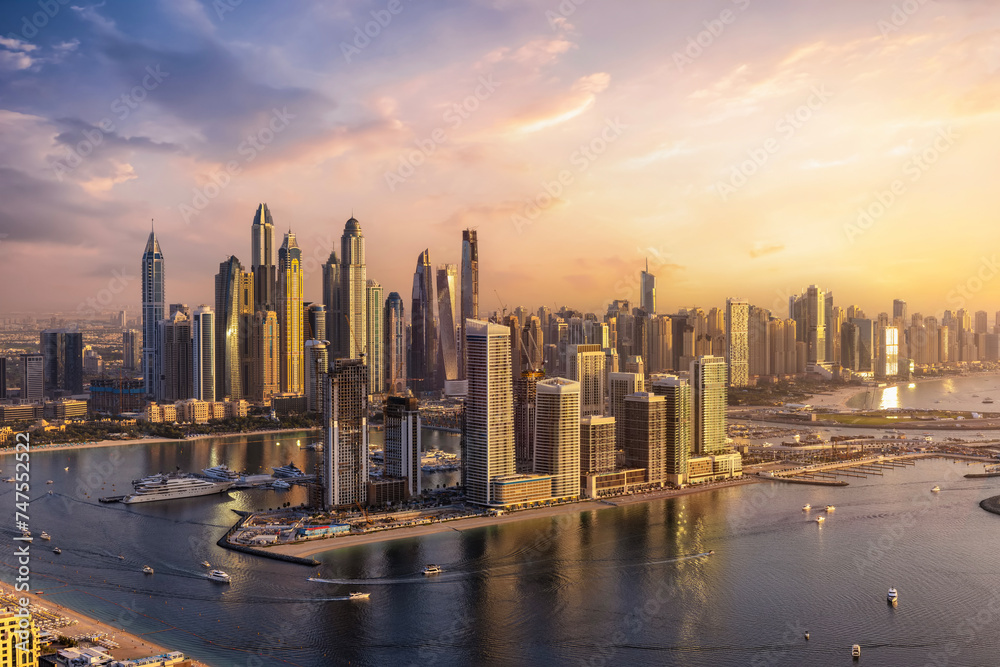 Panoramic view of the modern skyline of Dubai Marina with skyscrapers reflecting the warm sunset sunlight, United Arab Emirates - obrazy, fototapety, plakaty 