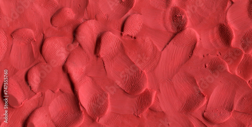 Raw red plasticine texture. Rough playdough textured background. Abstract modelling clay backdrop. Web banner, poster design or label design elements.