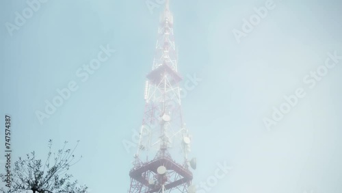High telecommunication tower for transmitting signals from satellites to televisions, radio or phones, signal receiver of 5g, 4g and 3g satellite connection, radio and TV antenna transmitter in
