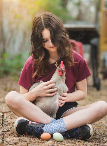 Young girl holding chicken in lap