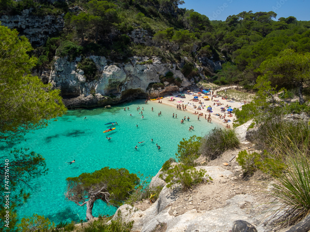 Small cove Cala Macarelleta between the green vegetation and white cliffs, Menorca