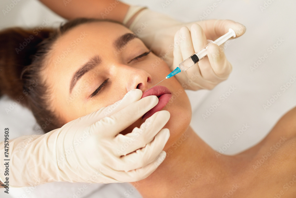 Beauty injection. Millennial woman making lip augmentation procedure