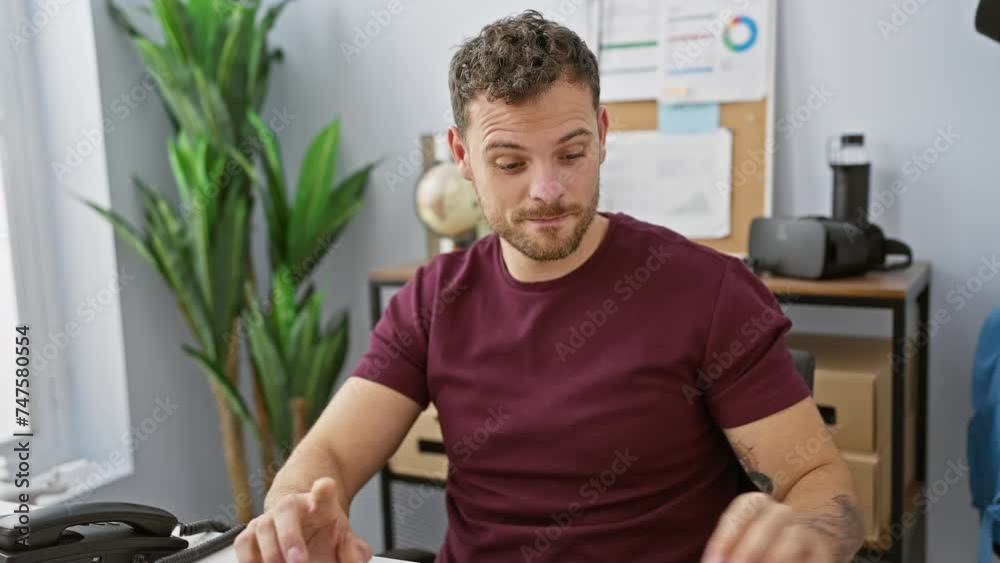Handsome young hispanic man with a beard wearing headphones while working in a modern office environment Handsome young hispanic man with a beard wearing headphones while working in a modern office environment