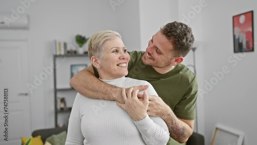 A middle-aged woman and a younger man sharing a heartfelt moment in a cozy living room. photo