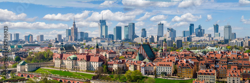 Warsaw old town and distant city center, PKiN and skyline under blue cloudy sky aerial landscape