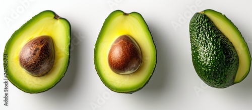 A photo featuring three avocados, one of which is cut in half, against a clean white background.