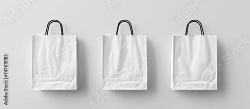 Three white paper shopping bags are suspended on a wall, creating a simple yet modern display.