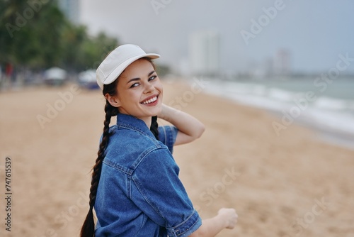 Happy Attractive Young Woman, Model Portrait with Pretty Hair, Enjoying Summer Leisure in a Casual Hat, Relaxing at the Beach with a Cheerful Smile © SHOTPRIME STUDIO
