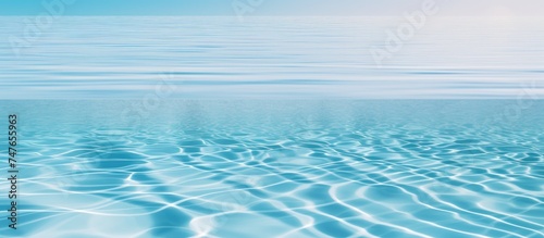 A view of a vast blue ocean with gentle ripples of water in the foreground, showcasing the beauty and serenity of the waters movement.